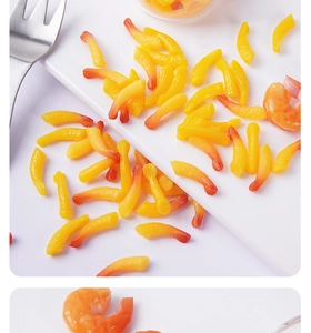 Macro detail of miniature resin tempura shrimp tails and shrimp kernels on a white tray