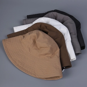 Detail of five multi-color wide brim bucket hats stacked to show fabric texture