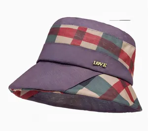 Detail view of purple plaid sun hat featuring gold LOVE letter charm and breathable texture