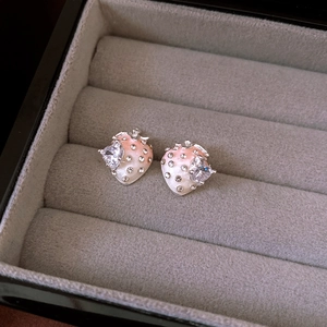 Vue macro détaillée de boucles d'oreilles fraises avec émail rose et cristaux brillants