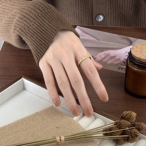 Close-up of a delicate gold ring with sparkling star details on a person's hand