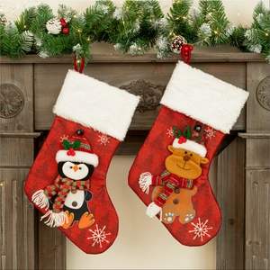 Festive red Christmas stockings with plush white cuffs and reindeer penguin embroidery