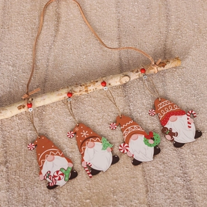 Close-up of four wood Christmas gnomes with candy cane and tree on a branch