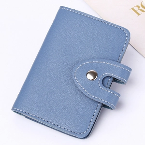Detail of blue lychee grain PU leather card holder with button closure and fine stitching