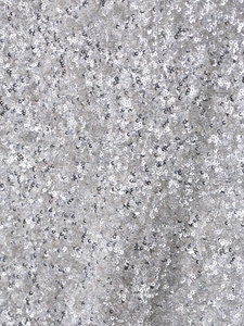 Détail macro du tissu à paillettes argentées avec un éclat métallique brillant