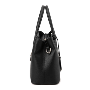 Close-up of black litchi pattern leather handbag with gold metal hardware details