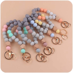 Silicone and wood beaded wristlet keychains with gold clasps in assorted pastel colors