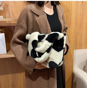 Detail view of a cow print plush tote bag with soft faux fur texture and large capacity