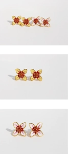 Macro detail of white and yellow enamel flower earrings with red stamen and gold edges