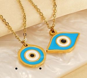 Macro detail of gold evil eye pendants with blue enamel on a polished chain