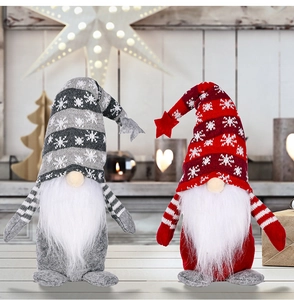 Detail of red and grey knitted Christmas gnomes with stars and soft festive background