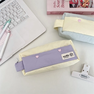 Detailed view of pastel canvas pencil cases with heart buttons and side handles
