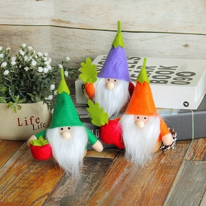 Three colorful handmade felt gnomes with tall hats and fruit accessories on a wooden table