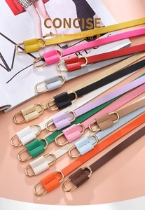 Flat lay of colorful thin faux leather belts with gold double ring buckles for dresses