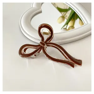 Detail of 11cm coffee and clear jelly bow hair claw clip on a mirror surface