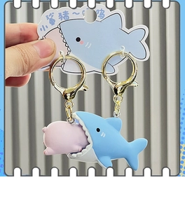 Close-up of shark and pig couple keychain with matte texture and gold lobster clasp