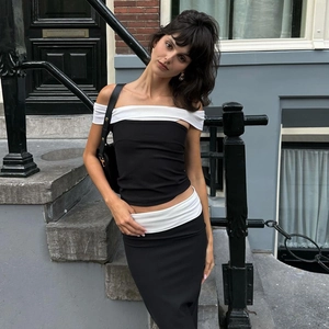 Outdoor street style shot of a woman in a black and white layered tube top and skirt set