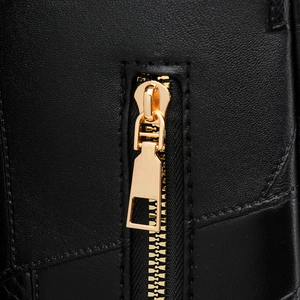 Macro view showing the black leather texture and gold metal zipper detail of the backpack