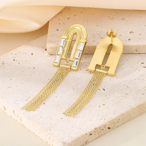 Détail de boucles d'oreilles en or 18k avec pierre rectangulaire et longues franges