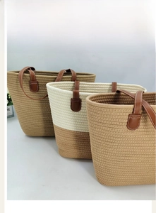 Detailed view of woven cotton tote bags with leather handles in three various colors