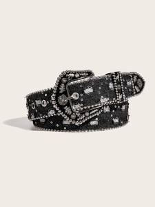 Detail of black denim belt with silver studs and engraved western horse buckle
