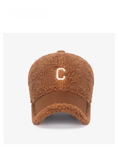 Detail of brown teddy fleece baseball cap with C embroidery and suede-textured brim