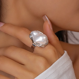 Detailed close-up of a silver baroque pearl ring featuring irregular textured metal edges
