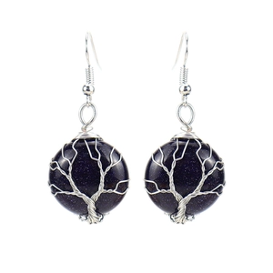 Detail of handmade wire-wrapped tree of life earrings with blue sandstone crystals