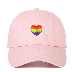 Pink cotton baseball cap featuring colorful rainbow heart embroidery on the front