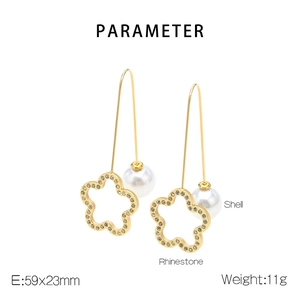 Detail view of gold drop earrings with shell and rhinestones showing 59x23mm dimensions