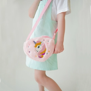 Detail of pink plush unicorn crossbody bag with adjustable strap on a girl model