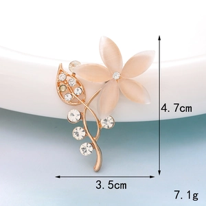 Macro shot of champagne floral brooch with opal petals and rhinestone details 4.7cm height
