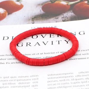 Boheems damesarmband met rode heishi-kralen van polymeerklei op een witte tijdschriftachtergrond