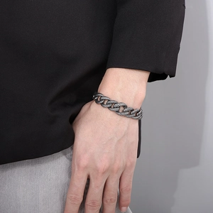 Detailed view of silver Cuban link bracelet with spiral texture on male wrist