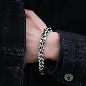 Close-up of men's silver stainless steel Cuban link bracelet with spring clasp on wrist