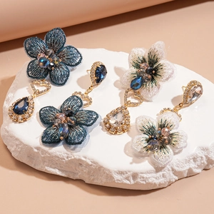 Détails de boucles d'oreilles vintage avec fleurs en tissu et gouttes de strass chic
