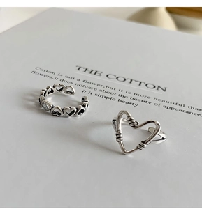 Macro shot of vintage style S925 silver rings with hollow heart designs and retro texture