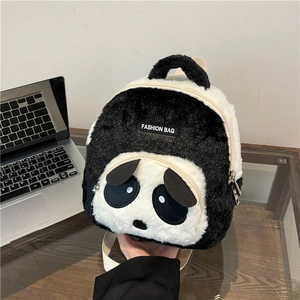 Detail showing the plush panda backpack texture with a Fashion Bag label on glass table