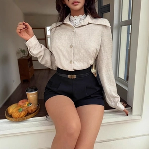 Detail of beige textured long-sleeved shirt featuring elegant lace-trimmed collar