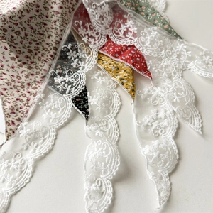 Dettaglio delle fasce per capelli floreali con pizzo bianco delicato e tessuto in cotone