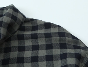 Detail of grey and navy plaid shirt showing the high-quality collar and shoulder stitching