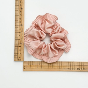 Macro shot of pink satin scrunchie with ruffled edges measuring 11.5cm in diameter