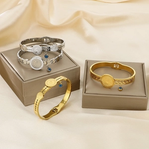 Gold and silver vintage coin bracelets with Evil Eye charms on a premium silk display
