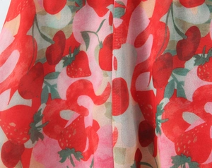 Gros plan sur un tissu mousseline léger avec motifs fraises et cerises rouges