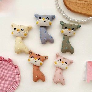 Close-up of five colorful cartoon giraffe embroidered cloth doll pendants for DIY crafts