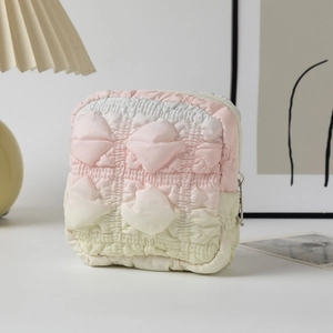 Close-up of pink gradient quilted cosmetic bag with bubble texture and silver zipper