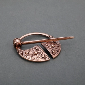 Detail showing vintage bronze Viking brooch with Celtic knotwork and embossed texture