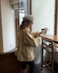 Detail of khaki tie-waist trench coat with large pockets and casual lapel design