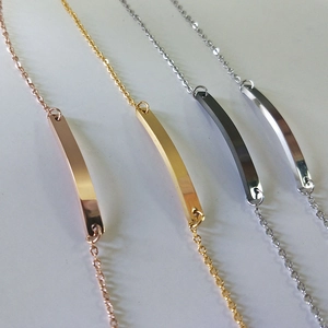 Detailed view of curved metal ID bracelets in rose gold, gold, grey and silver finishes