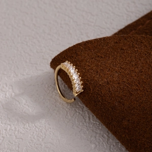 Macro shot of gold non-piercing nose ring featuring leaf pattern and rectangular zircons
